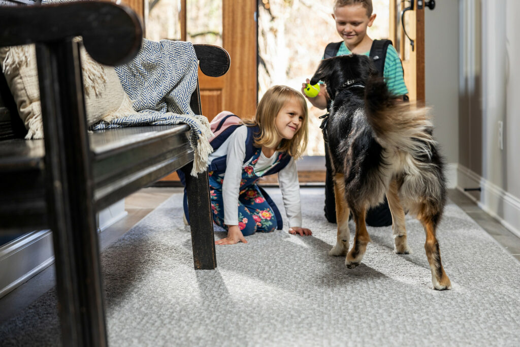 Kids plying with dog on carpet flooring | Floor Boys
