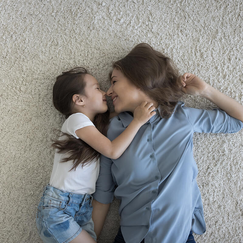 Mother and child laying on kid friendly carpet